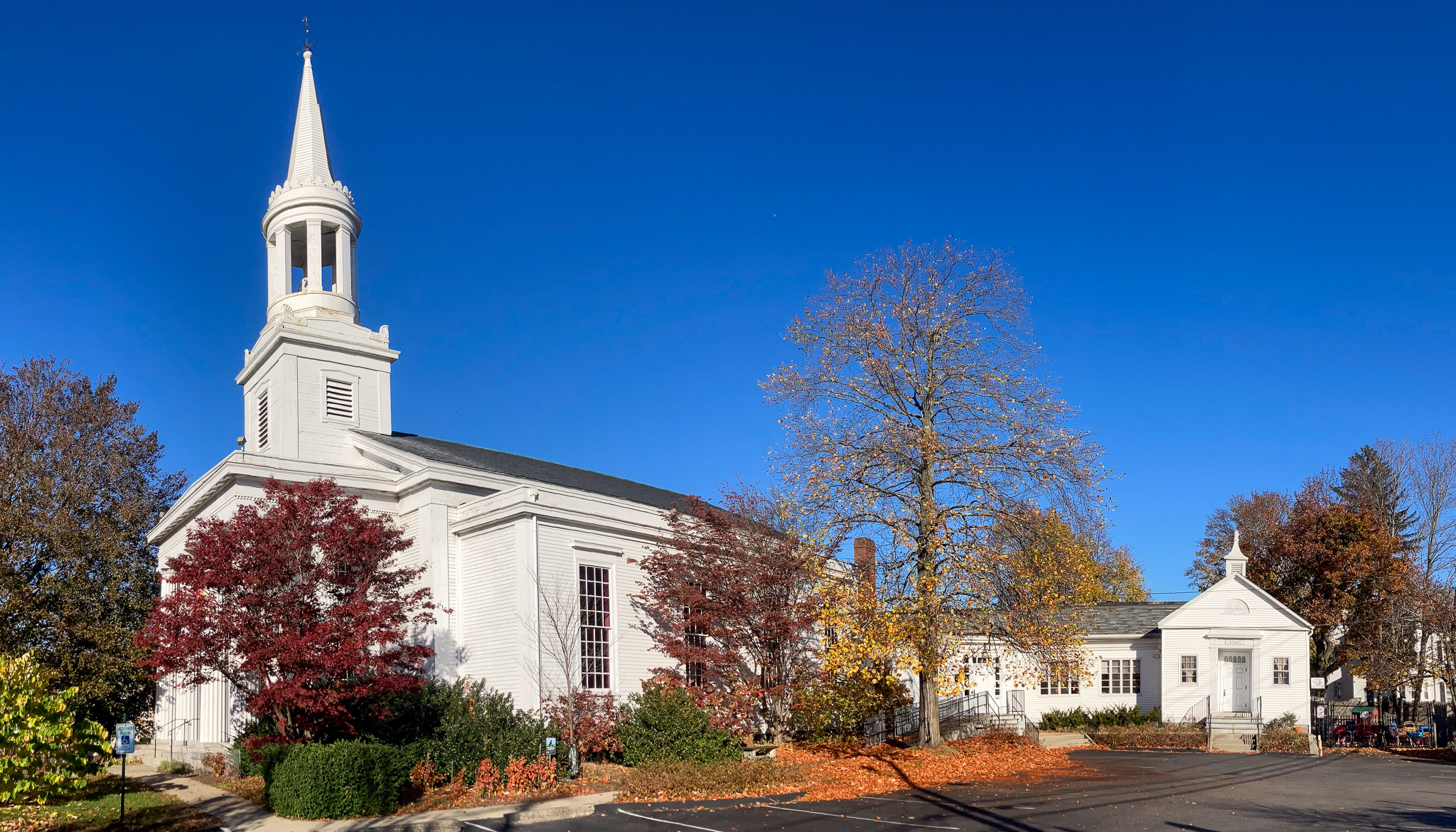 panoramic view of church including steeple, side entrance, and chapel